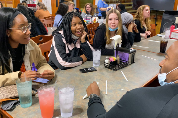 Students and staff talk at a meal on Nazareth's Civil Rights Journey