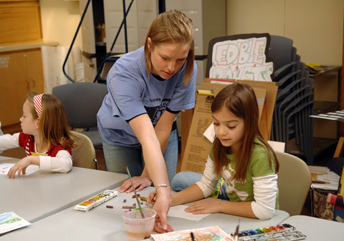 a student helping a child paint
